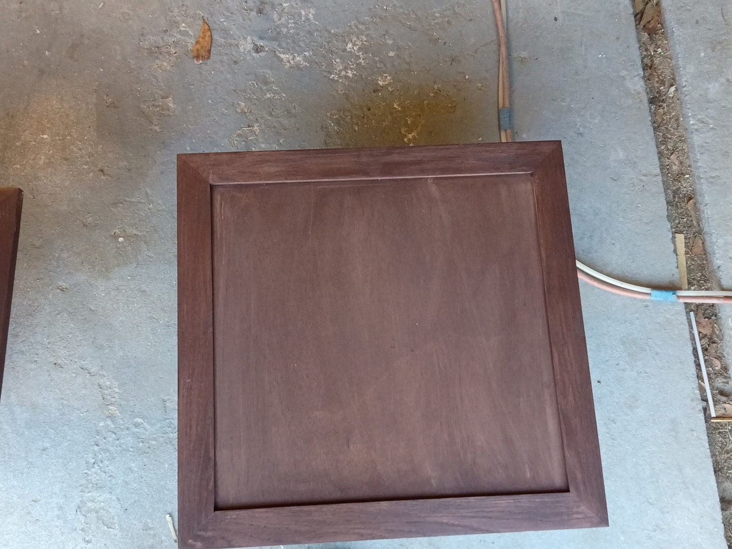Dark-stained cabinet door panel finished and laid out in the shop.