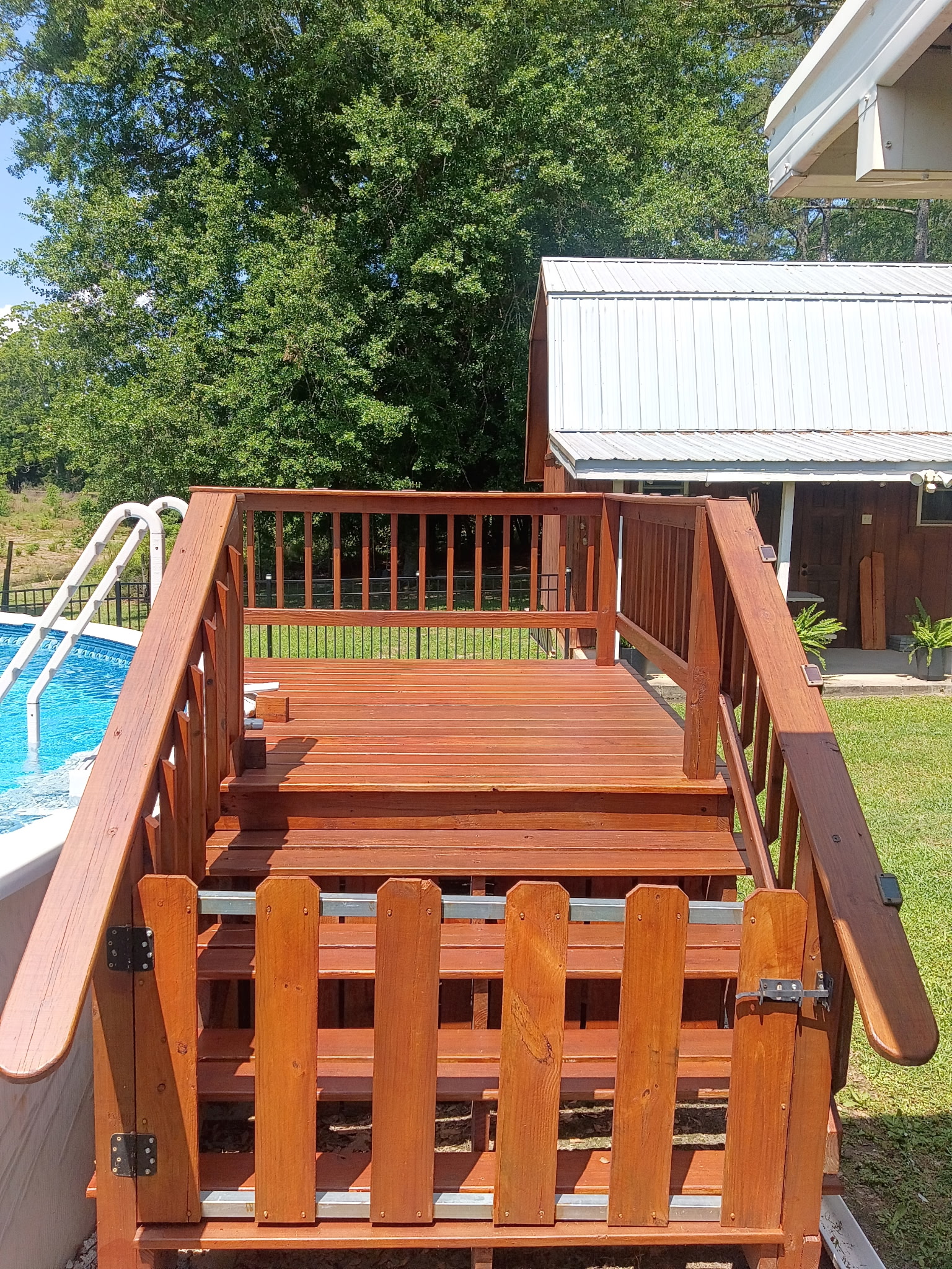 Finished cedar-stained deck with railings overlooking a yard.