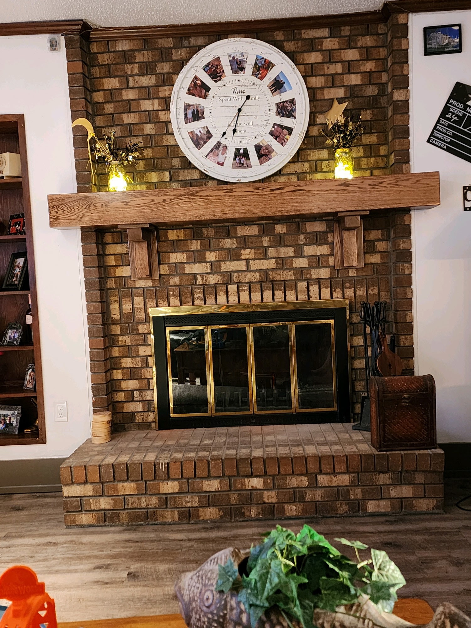 Brick fireplace with a stained wood mantle and clock display.