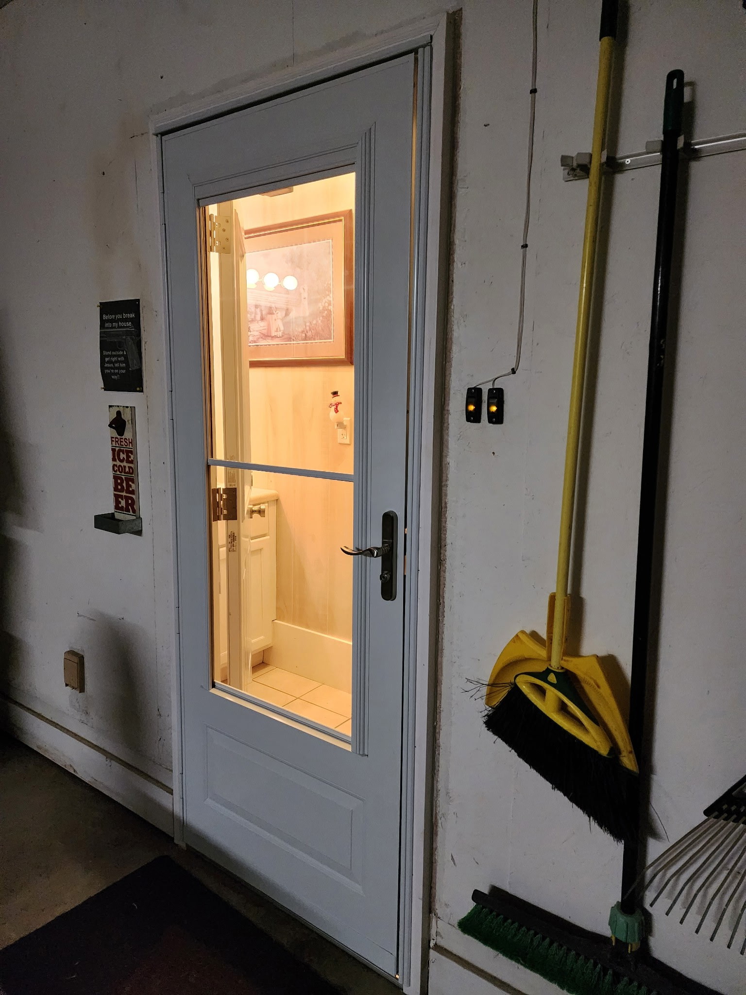 New interior glass-paneled door installed in a hallway with broom hooks alongside.