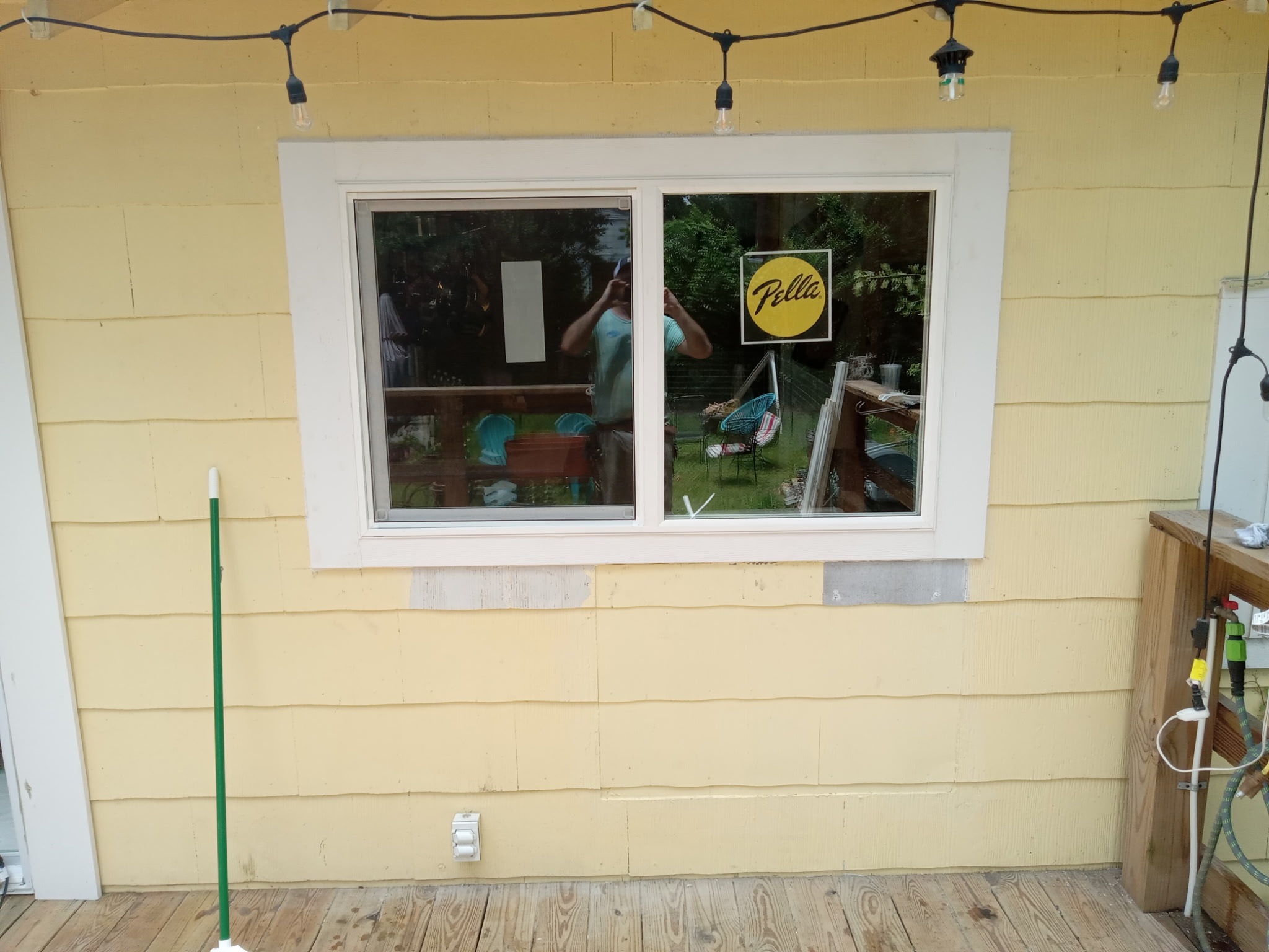 New Pella window installed in yellow lap-siding exterior wall.